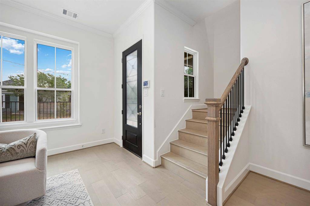 Your “wow” moment starts right here. Between the natural light, iron railings, and warm wood treads, the vibe is polished—but still totally livable.