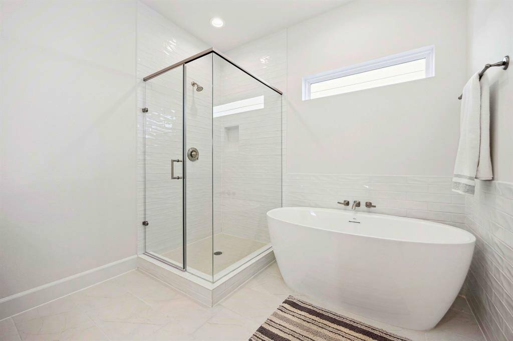 Steam it out or soak it in—this spa-like setup gives you both. Frameless glass, sculptural tub, and that “ahhh” factor.