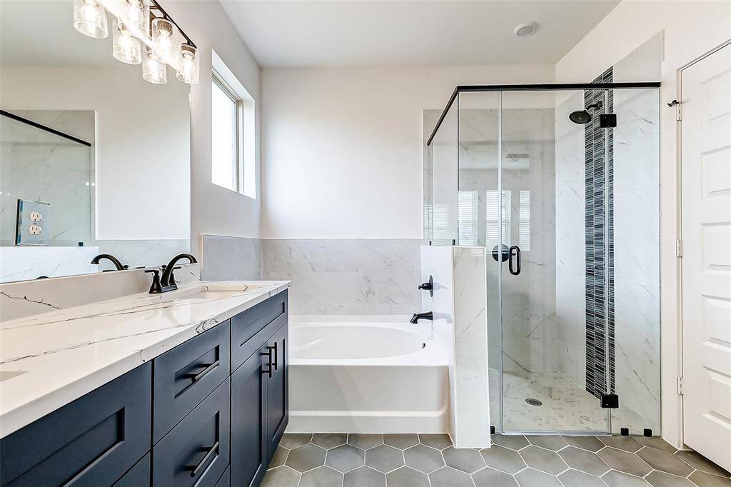 This primary bath blends modern luxury with classic design, featuring a spacious glass-enclosed shower, a relaxing soaking tub, and high-end finishes. This is a picture of a Rylan Floor Plan from another Saratoga Homes.