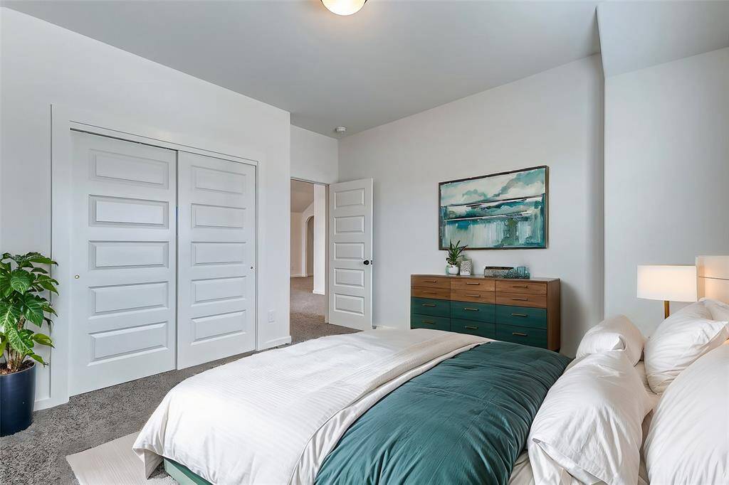 A cozy and inviting bedroom with plush carpeting and ample natural light. The spacious closet and soft neutral tones make it a perfect retreat. **This is a picture of a Rylan Floor Plan from another Saratoga Homes.**