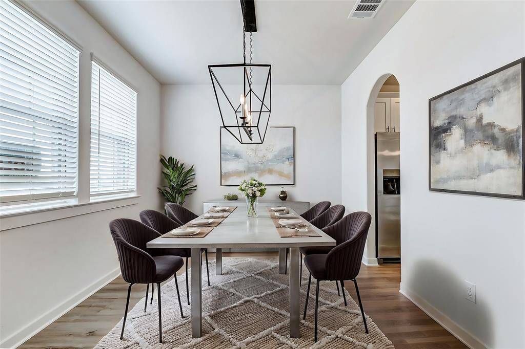 Bright and inviting, the dining area features large windows that let in abundant natural light. The modern chandelier adds a touch of elegance, making it the perfect space for intimate dinners or festive gatherings. **This is a picture of a Rylan Floor Plan from another Saratoga Homes.**
