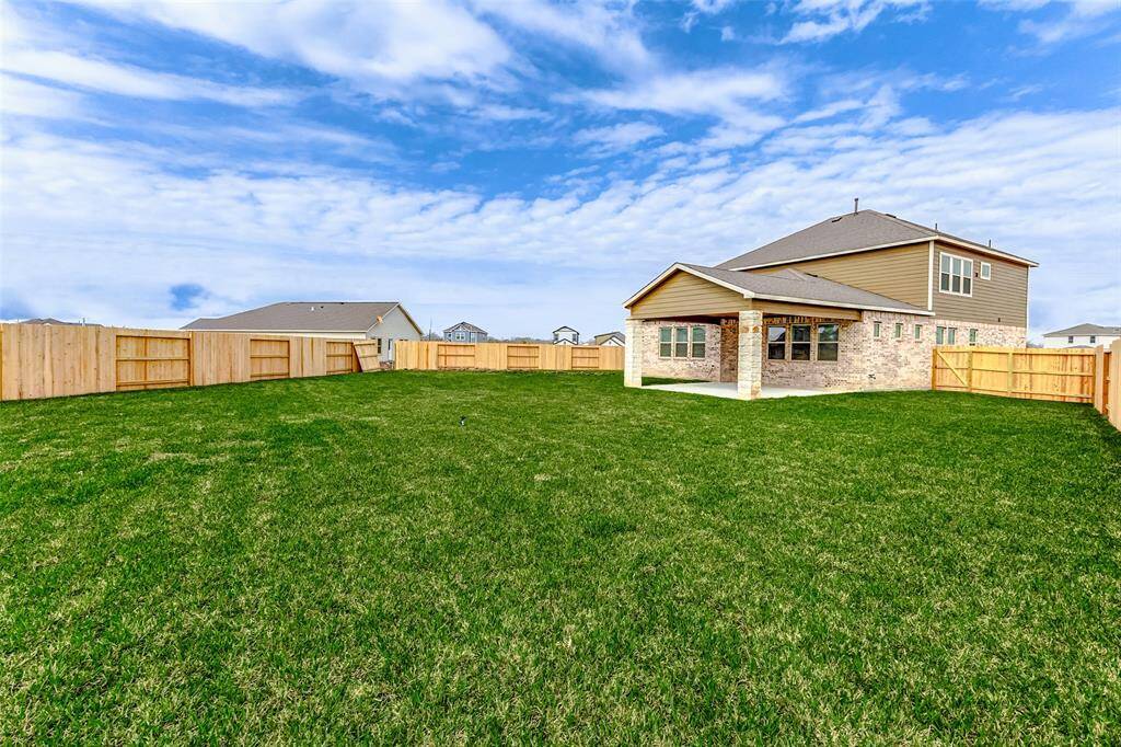 This oversized backyard offers endless possibilities for gardening, playtime, or even a future pool! Bordered by a beautiful wooden fence, the open sky and well-manicured lawn provide a serene escape. **This is a picture of a Rylan Floor Plan from another Saratoga Homes.**