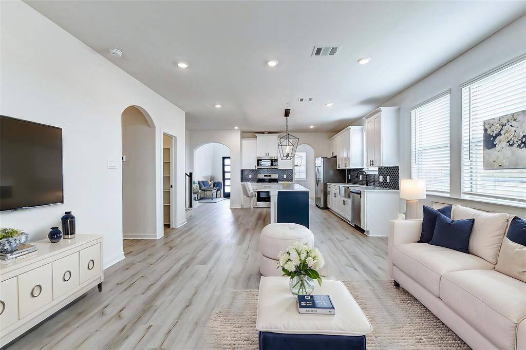 A beautifully designed open floor plan that seamlessly connects the kitchen, dining, and living spaces. Large windows flood the space with natural light, creating a bright and airy feel.**This is a picture of a Rylan Floor Plan from another Saratoga Homes.**