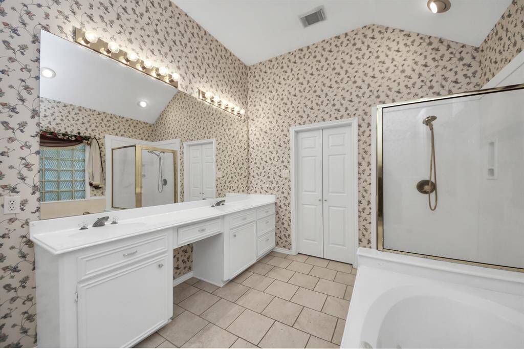 The ensuite primary bathroom offers dual sinks and a dedicated vanity area, perfect for makeup application and everyday convenience.