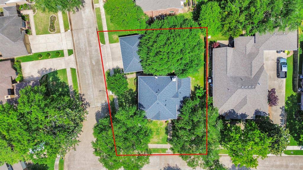 An aerial view of the property highlights the spacious layout, showcasing the expansive backyard, corner lot, and ample room for outdoor activities.