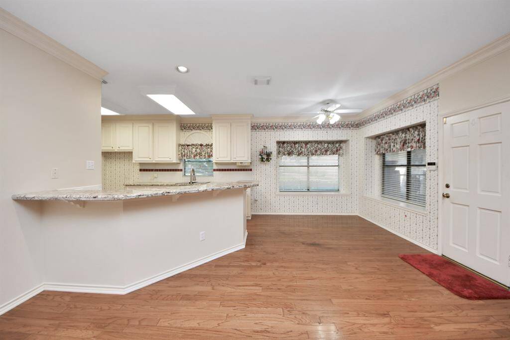 The combined breakfast area and kitchen provide a perfect space for cooking and enjoying casual meals. A convenient breakfast bar offers extra seating, perfect for entertaining.