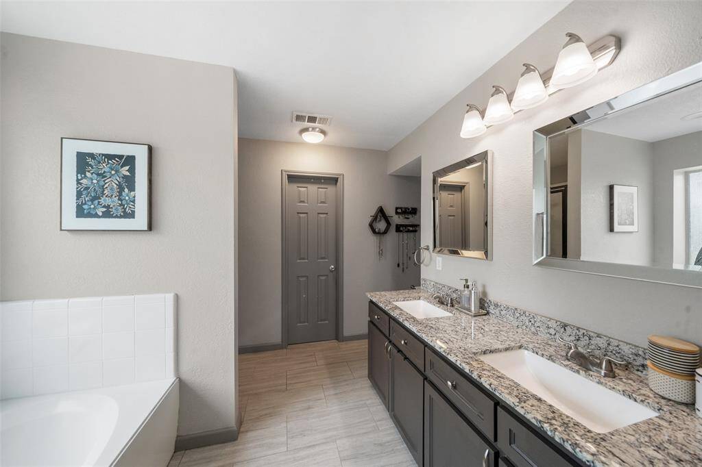 A view of the en suite bath complete with double sinks and walk in closet