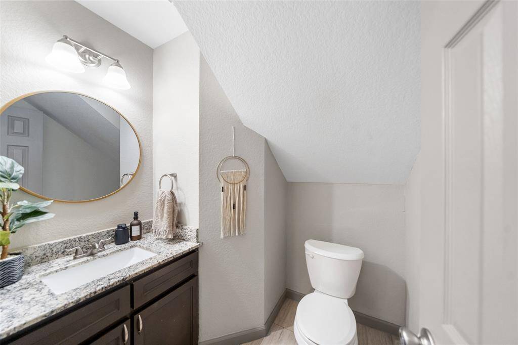 A view of the guest bath downstairs, recently updated with new counter, vanity and lighting.