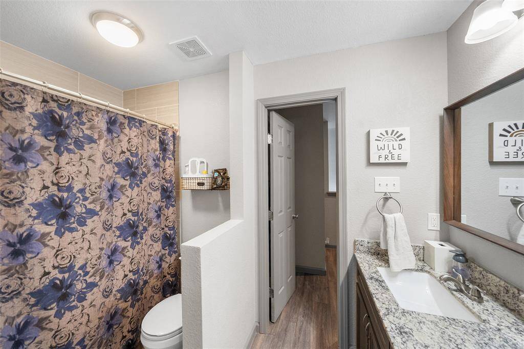 Secondary bath upstairs with granite counters and a sizable shower/tub combo.