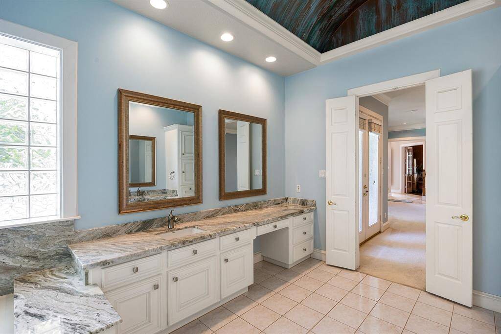 Primary suite includes stunning faux painted barrel ceilings, a sitting area, spa access, and a luxurious bath with granite, whirlpool tub, and oversized shower and large walk-in closet