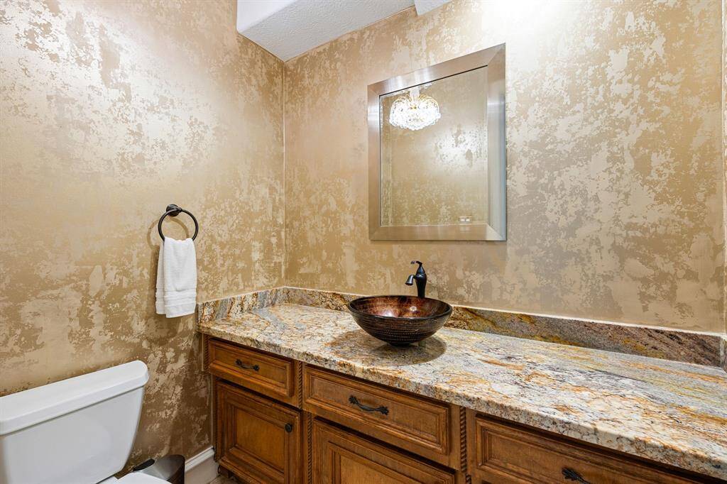Half bathroom located on first floor off of utility room near backyard access to pool
