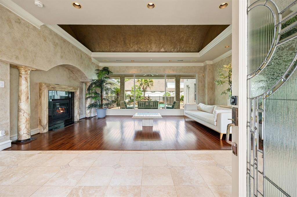 Enter into the living room wall of windows overlooking the pool. Warm, inviting, and full of natural light