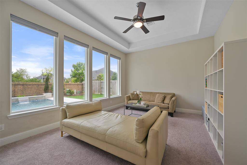 The spacious game room is conveniently located just off the family room, creating an ideal space for fun and relaxation. With a light-filled atmosphere, the room features a wall of windows with pull-down shades, offering views of the backyard. The low-profile carpet adds comfort, while the generous size of the room provides ample space for various activities and entertainment options.