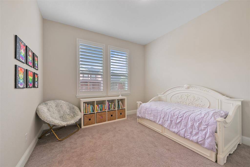 This inviting Secondary Bedroom #2 features low-profile carpet, a window with added plantation shutters, and a ceiling fan/light fixture for added comfort. The walk-in closet provides convenient storage. The room shares an hollywood bathroom with Secondary Bedroom #1.