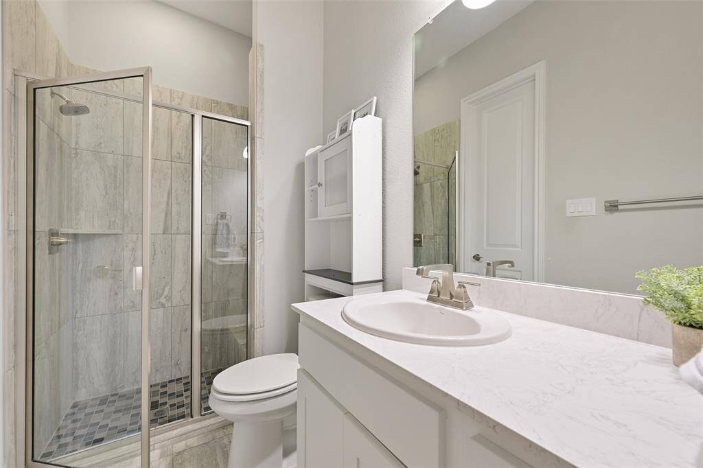 The private en-suite bathroom for Secondary Bedroom #3 includes a walk-in shower with a bench for added comfort, as well as a vanity with storage and a luxurious Venetian marble countertop. Vanity lights provide ample illumination, and the walk-in closet offers plenty of space for organization and storage.