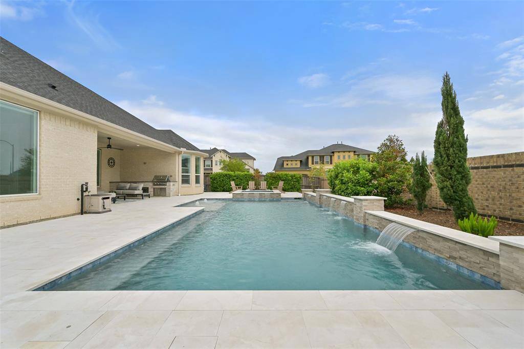 Incredible backyard paradise features a stunning pool & spa plus an outdoor kitchen, covered patio & grass space; offering a perfect blend of relaxation & entertainment. Fully fenced for privacy, it offers a spacious and well-designed layout that seamlessly blends outdoor living with comfort. Whether you're hosting friends or enjoying a quiet evening, this backyard has it all. The home also backs up to one of the many playgrounds in the community!