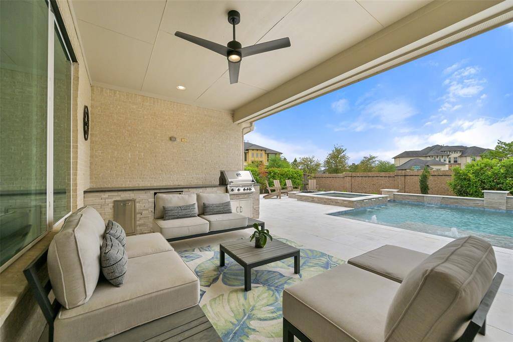 The large covered patio is designed for effortless outdoor living, featuring ample space for furniture and dining al fresco. The outdoor kitchen, added in 2021, is a chef’s dream with a built-in grill, mini fridge, and storage, making it ideal for entertaining. A ceiling fan/light fixture ensures comfort, even on warmer days.