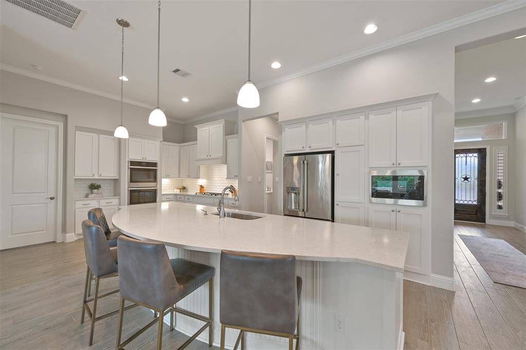 Equipped with top-of-the-line appliances, this kitchen is sure to impress. The new ‘24 stainless steel dishwasher, GE stainless steel 5-burner gas cooktop, & double ovens elevate the cooking experience, while the ‘23 GE built-in microwave adds convenience. A stainless steel one-basin sink, pull-out trash drawer, & pot/pan drawers provide practical touches. For extra storage, a huge walk-in pantry with an appliance shelf keeps everything organized. Abundant cabinet space ensures you’ll have room for all your