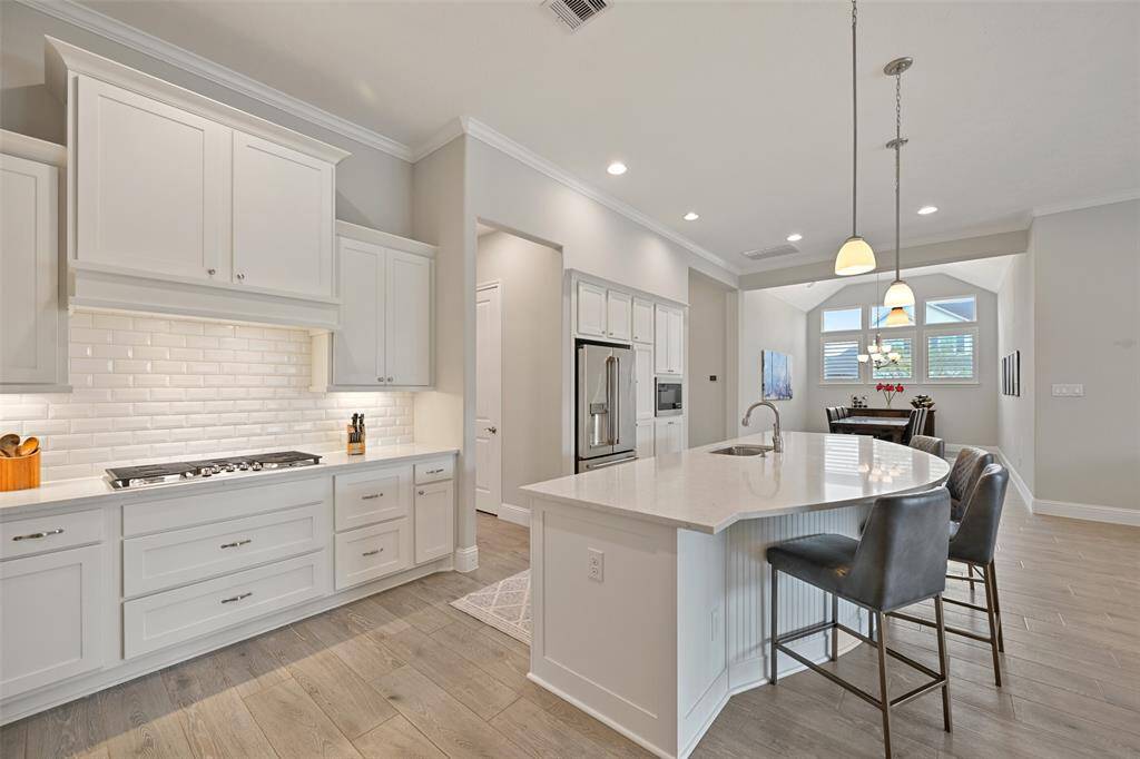 Equipped w/ top-of-the-line appliances, this kitchen is sure to impress. The new ‘24 SS dishwasher, GE SS 5-burner gas cooktop, & double ovens elevate the cooking experience, while the ‘23 GE built-in microwave adds convenience. A SS one-basin sink, pull-out trash drawer, & pot/pan drawers provide practical touches. For extra storage, a huge walk-in pantry w/ an appliance shelf keeps everything organized. Abundant cabinet space ensures you’ll have room for all your kitchen essentials.