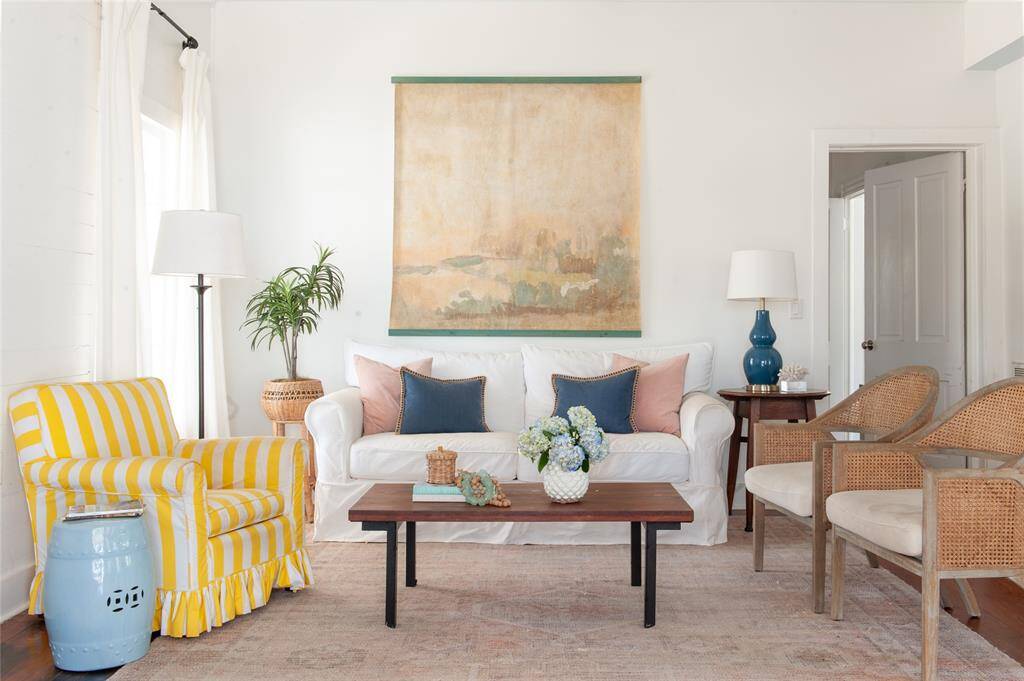 Bright and inviting living room features a large wall art piece, natural light, and tasteful decor, creating a warm, welcoming atmosphere.