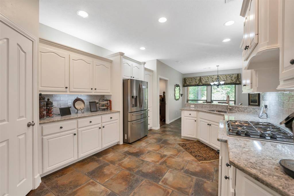 Kitchen has a gas cooktop, under cabinet lighting and ample cabinets and countertop space