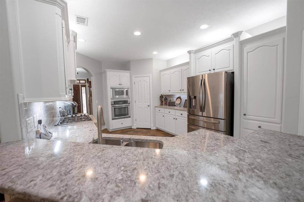 Cambria Quartz countertops and a double basin sink with elegant backsplash