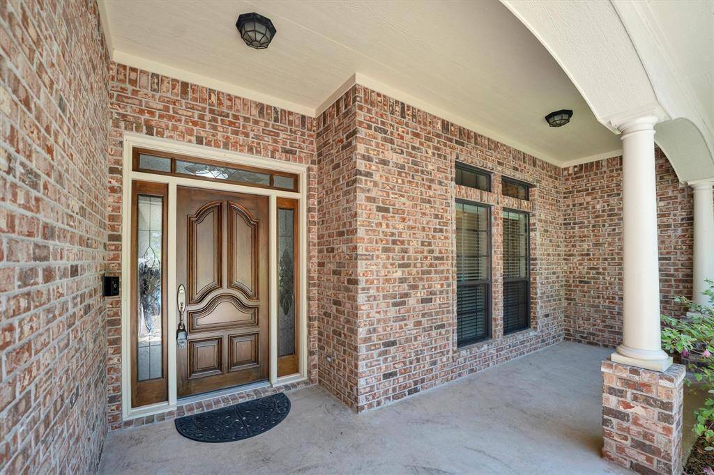 Covered front patio with decorative privacy glass around the front door to let in light