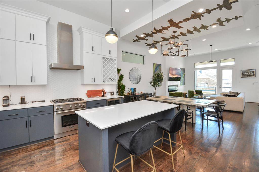 Well designed kitchen with gas range, wine rack, kitchen island, and quartz countertops.