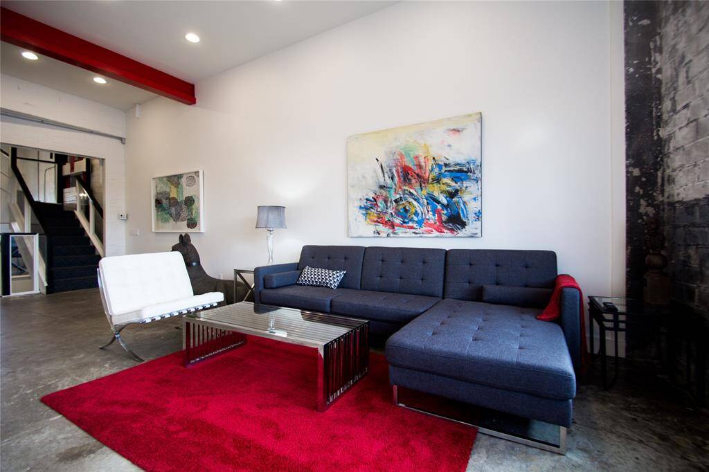SECOND FLOOR LIVING AREA WITH EXPOSED METAL BEAMS & EXPOSED BRICK WALLS.