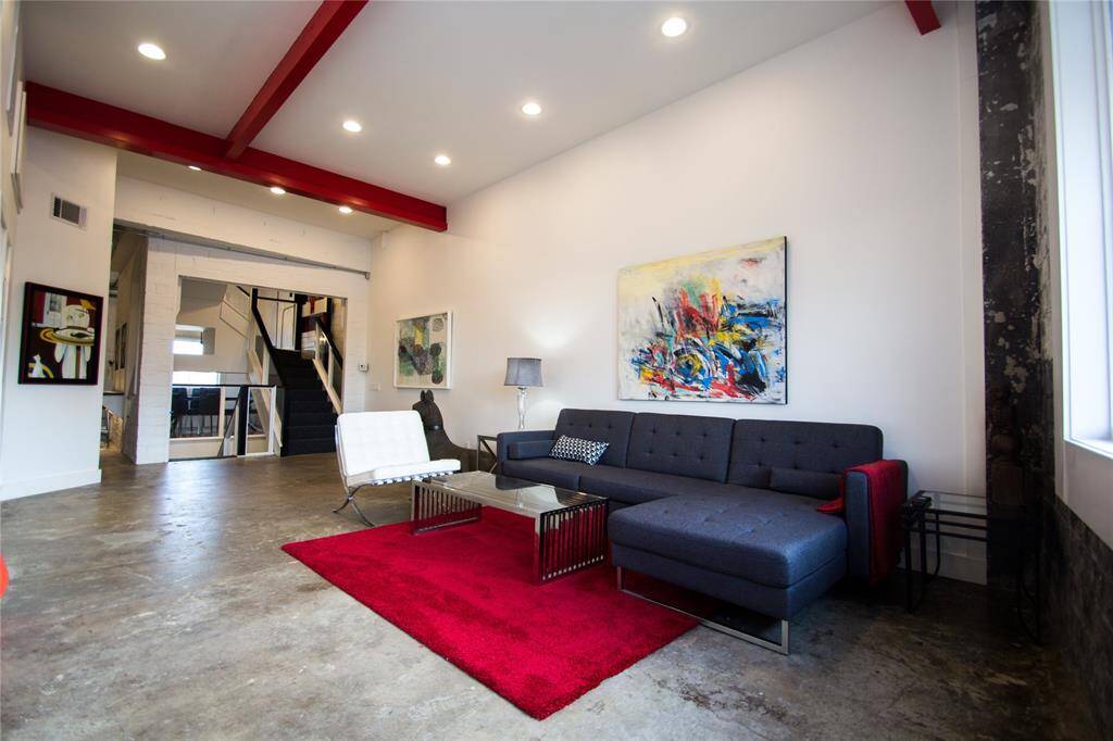 SECOND FLOOR LIVING AREA WITH EXPOSED METAL BEAMS AND EXPOSED BRICK. FEATURES KITCHEN, BREAKFAST ROOM, HALF BATH AND STORAGE CLOSET.
