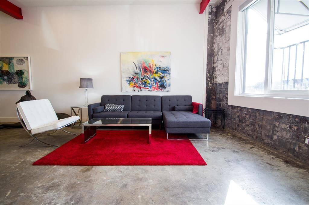 SECOND FLOOR LIVING AREA WITH EXPOSED METAL BEAMS AND EXPOSED BRICK WALLS. FEATURES KITCHEN, BREAKFAST ROOM, HALF BATH AND STORAGE CLOSET.