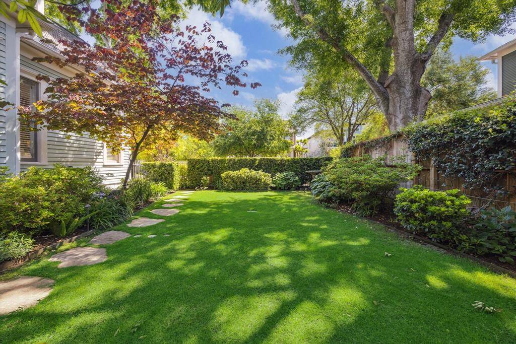 French drains in the front and side yards help prevent standing water, while the side yard showcases a seamless blanket of zoysia grass, offering both visual appeal and durability.