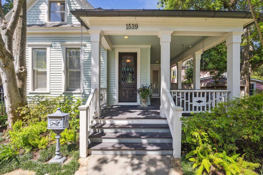 This entry is pure charm - anchored by a wide front porch wrapped in wood railings with diamond-inlay detail. To the right, a timeless porch swing gently hangs beneath—perfectly placed for slow mornings and golden hour conversations. Add in the cast-iron mailbox and thoughtful landscaping, and this porch doesn’t just welcome you - it sets the entire stage.