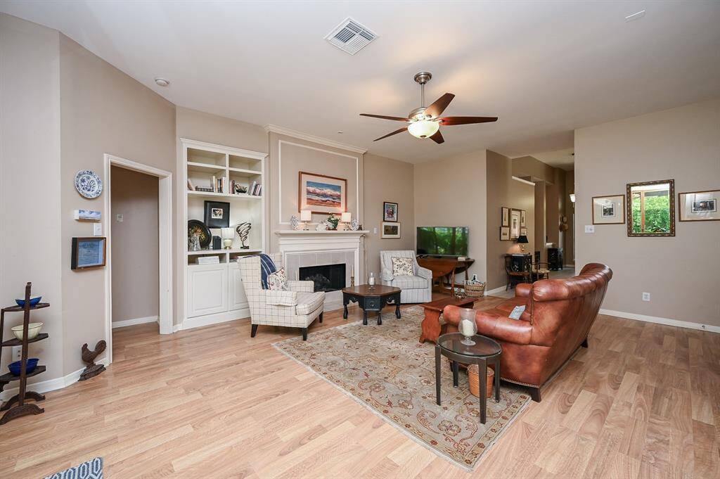 An elegant fireplace with custom millwork anchors the space, while built-in shelving offers functionality and charm.