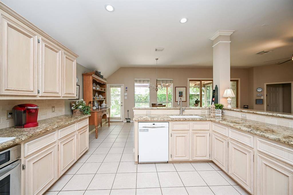 Enjoy a wide-open view from the kitchen into the dining space, where large windows bring in natural light.