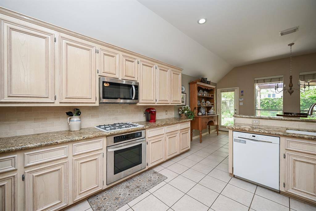 An entire wall of cabinetry and counter space provides abundant storage and workspace. The built-in microwave and oven combo is neatly integrated, keeping everything within reach for a streamlined cooking experience.