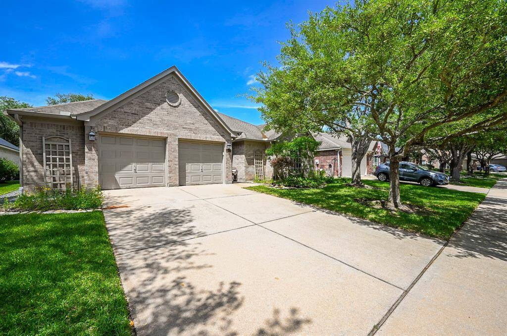 Charming single-story brick home with mature trees and a spacious double driveway leading to a two-car garage with a 4' extension.
