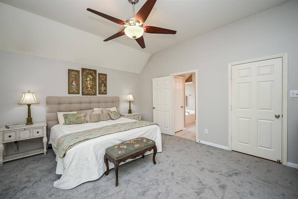 This spacious primary suite offers a thoughtful layout with direct access to the ensuite bath. A generous footprint allows for a sitting area or reading nook, while oversized windows and a ceiling fan enhance comfort and tranquility.