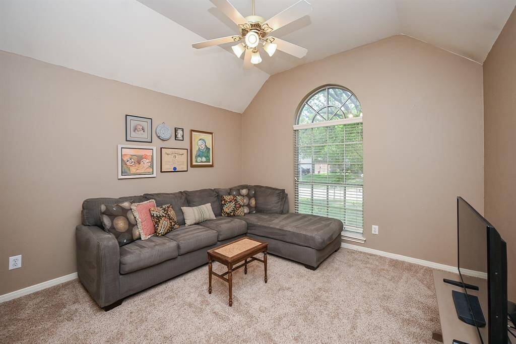 Spacious bedroom with vaulted ceilings and a large arched window allowing in abundant natural light—ideal as a game room, media room, or home office.