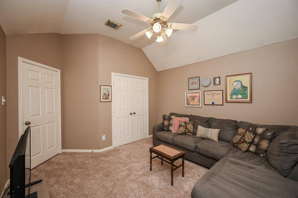 This multi-purpose room offers a cozy layout with plush carpeting & vaulted ceilings.