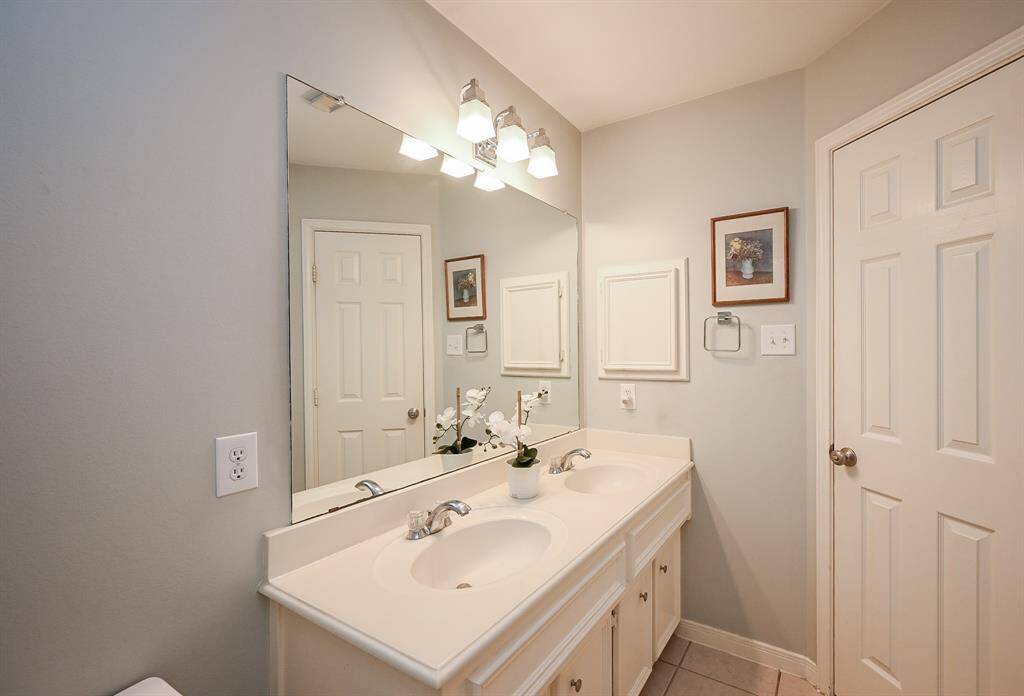 Another angle of the secondary bath showcasing ample countertop space and clean, modern finishes.
