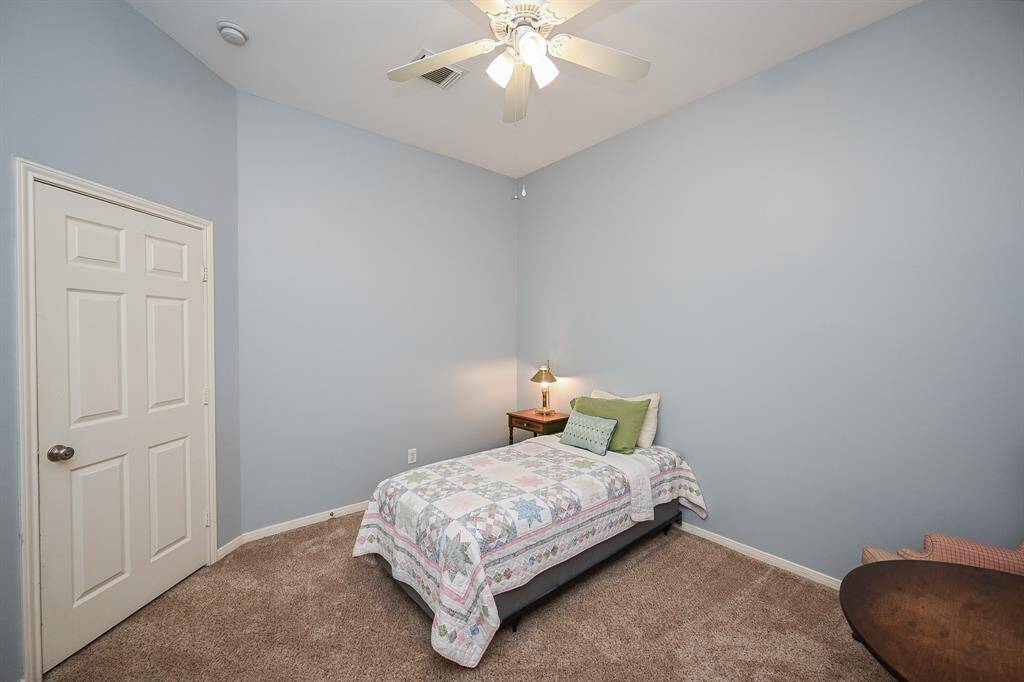 Another view of the second bedroom highlights the open layout and calming color palette