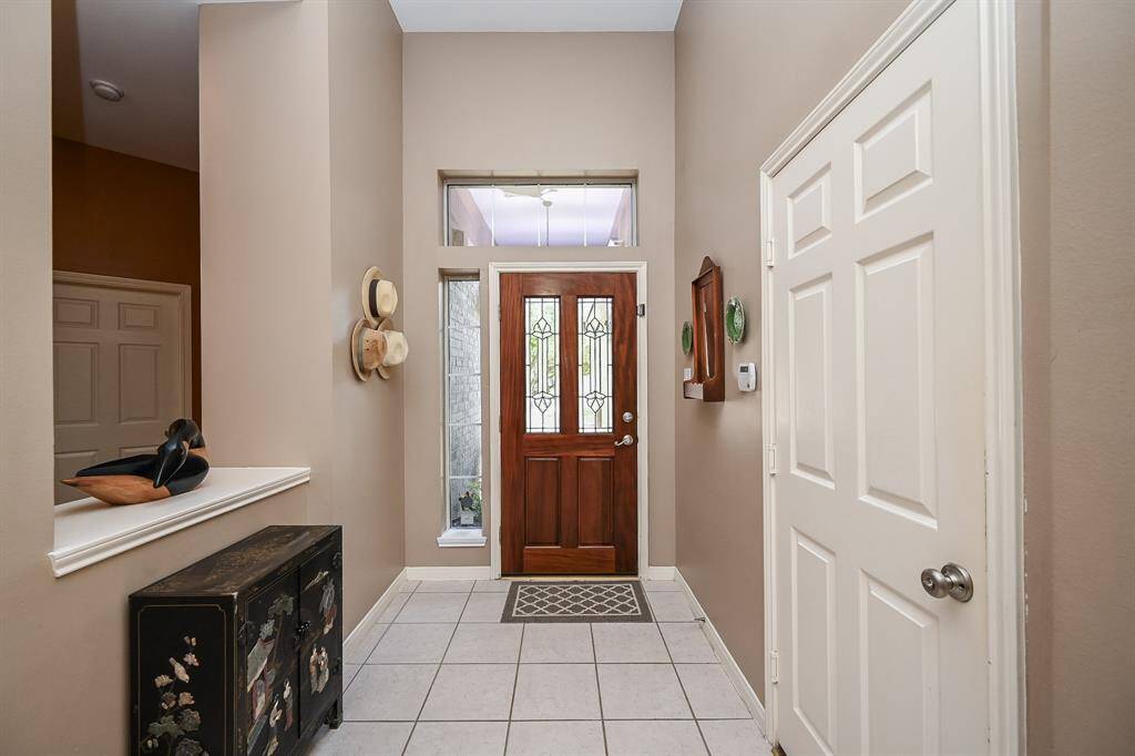 Bright entryway with high ceilings and tile flooring, creating an open and airy welcome into the home.