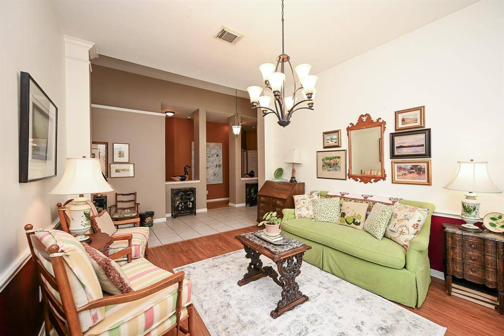 Flowing layout from the formal sitting room into the foyer, offering a glimpse of the home's open design and tall ceilings.