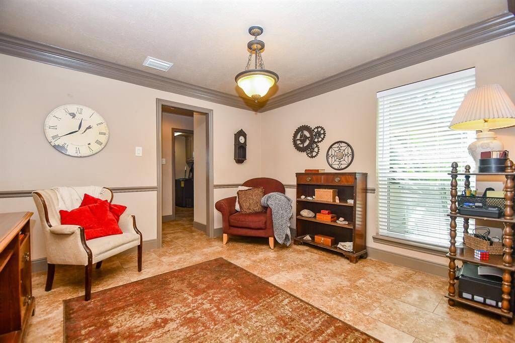 This formal dining area features crown molding, tile flooring, and ample natural light from a large window. Ideal for holiday meals with family; or as a reading nook or even home office space.
