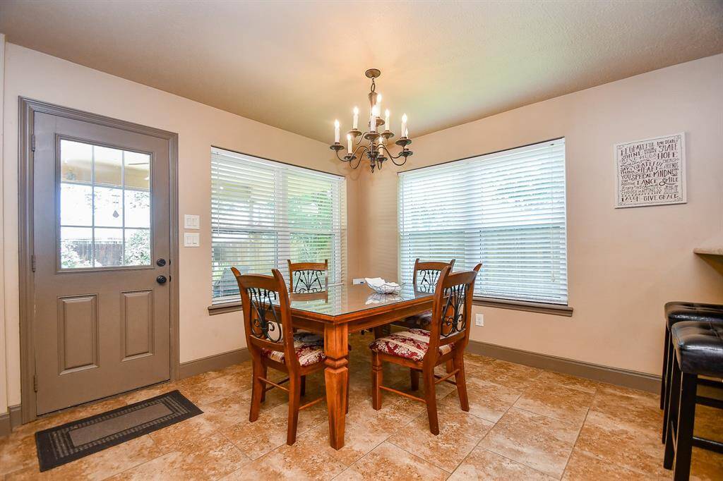 A cozy breakfast area set against two large windows providing natural light. The space offerss easy access to the covered patio and pool in the backyard.
