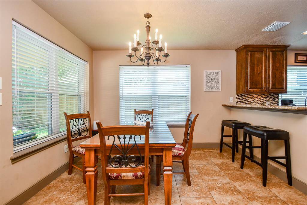 Bright dining area with large windows.  The adjoining kitchen area has a bar counter with room fir stools - perfect for family and fun!