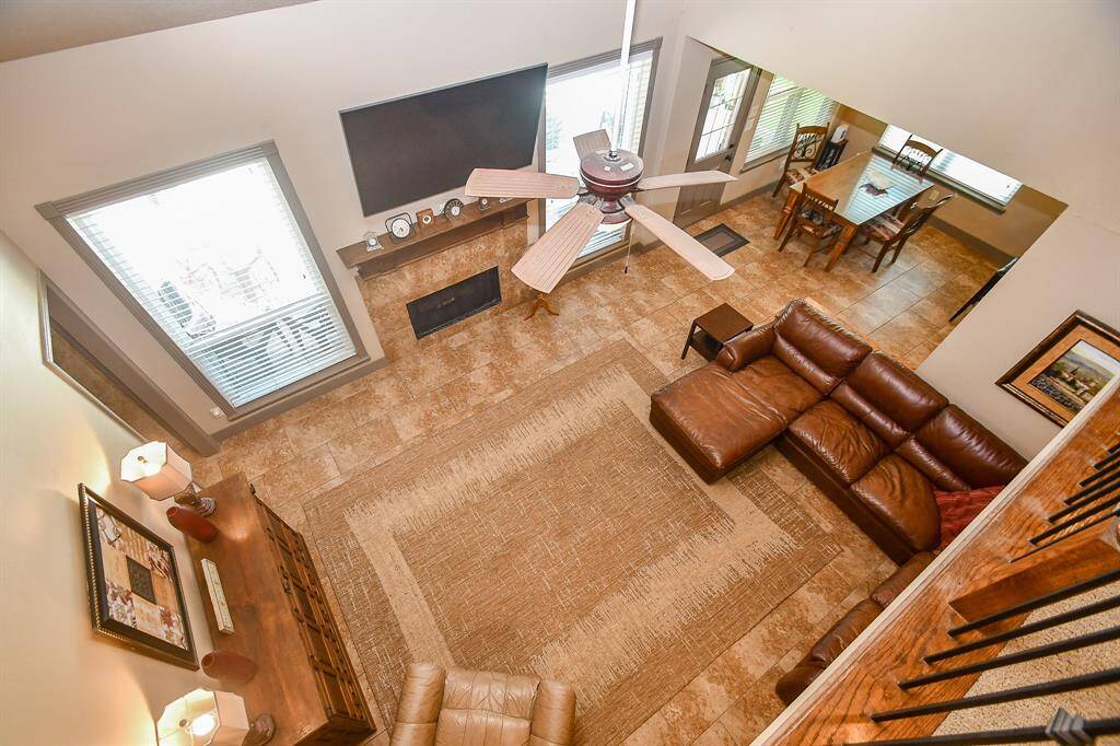 Spacious open-concept family area with high ceilings. Natural light floods through multiple windows, and the room opens to a dining area....with a great view into the backyard paradise!