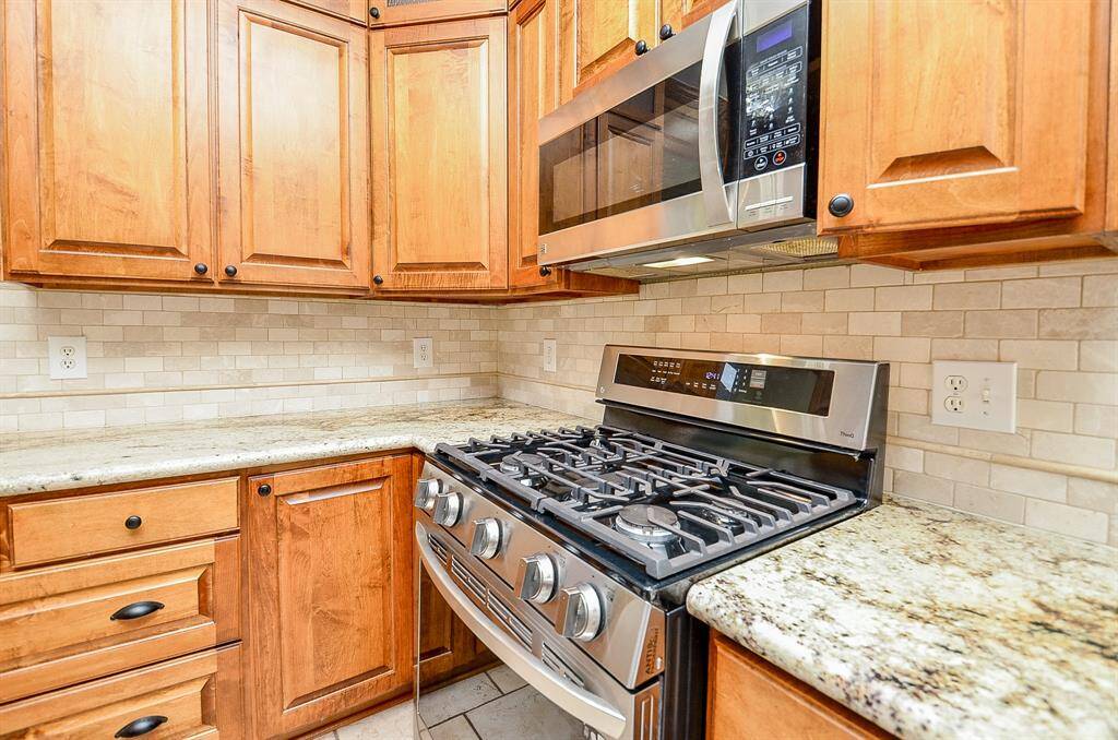 Kitchen boasts Custom Cabinets & Island, Granite Counters, Tiled Floor & Stainless Steel Appliances, Brand New Range.