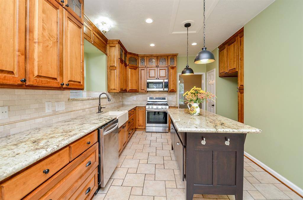 Kitchen boasts Custom Cabinets & Island, Granite Counters, Tiled Floor & Stainless Steel Appliances, Brand New Range.